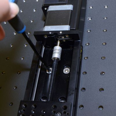 Move the LSQ stage carriage (by hand or using the manual control knob on the controller) to allow access to the eight mounting slots (four at each end of travel). Loosely mount the first X-axis stage to a breadboard or other mounting surface using the provided M6 low profile screws and a 4 mm hex key. Install screws until snug, then back off a little to allow alignment. Repeat until all screws are present.