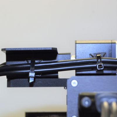 For cables to Z/theta and end effector devices, route the cable(s) beside the Y-axis stage and use an adhesive-backed cable tie mount (provided in the CGxxT kit) and a cable tie to hold the cable in place as shown.