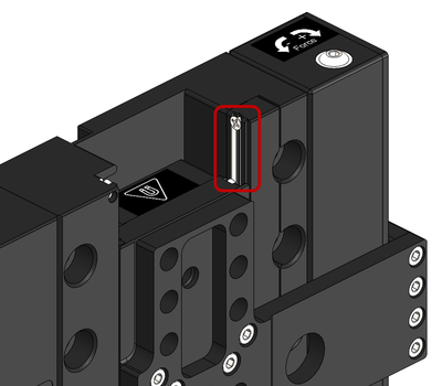 1. Manually move the stage to a travel limit to expose the linear guides. 2. Using a lint free cloth, wipe away any old grease and debris on the v-channels of the guides. Wipe towards the outside of the stage so debris is not pushed into the roller bearings. 3. Apply a thin strip of lubricant over the entire exposed length of the v-channels with a syringe. 4. Manually move the stage to the opposite travel limit and repeat steps 2 and 3 on the opposite side.