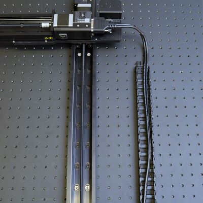 Lay cables in the guides, ensuring that the peripheral connectors are exiting the top end of the guide. Remove any twists in the cable(s) and lay them in the centre of the guide. Minimize twists outside the cable guide. Important: If you are using a Y-axis cable guide, ensure that the cable(s) for the Z/theta axis and any end effectors are also included in the X-axis cable guide.