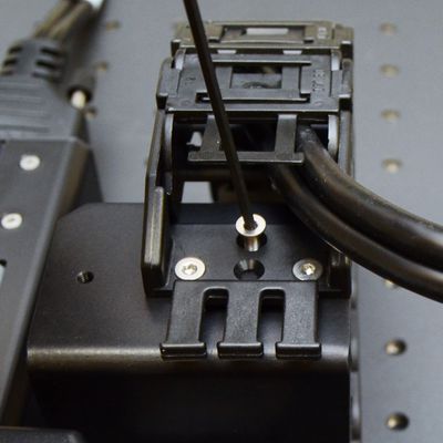 Attach the upper termination of the cable guide to the AP199 part 2 using three M3 flathead screws and the 2 mm hex key. Move the X-axis stages through their full travel to determine a good mounting location (typically around mid-travel) for the AP199 part 1 and mount it down with the provided long M6 low profile screws and a 4 mm hex key.