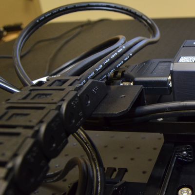 Ensure cables for Z/theta and end effectors have a 150-200 mm (6-8 inches) loop as they exit the X-axis cable guide. Route the cables under the AP198/AP199 top plate as shown before attaching cable guides.