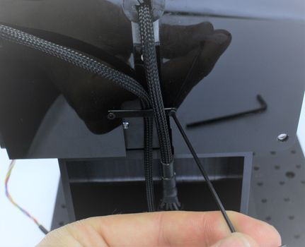 Use a 1.5 mm hex key to remove the M2 screw on one side of the strain relief strap.