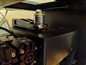 Lower the objective by pressing button 1.