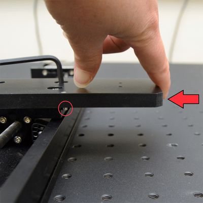 Push the AP200 plate as shown until the dowels on the bottom of the plate are both firmly in contact with the edge of the LSQ carriage - this provides Y-axis alignment. While holding the AP200 in place, firmly tighten the M6 fasteners using the 4 mm hex key. Note: Tightening in several steps, while alternating screws diagonally, may help prevent the plate from moving during this step.